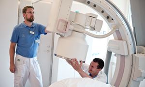 Medicinteknik Två tekniker manövrerar en medicinteknisk maskin