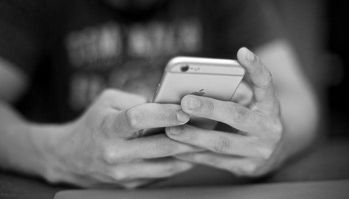 Händer som håller mobiltelefon