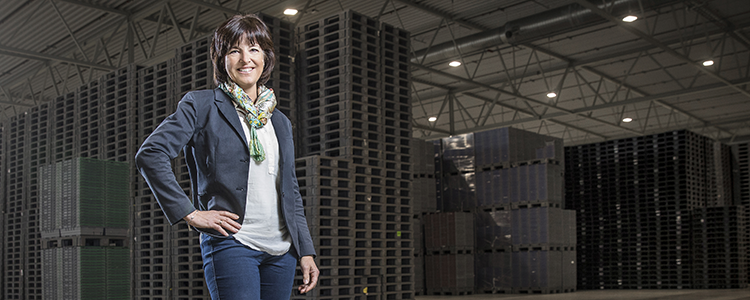 Anna Elgh, vd svenska returssystem- Lastpallar i bakgrunden.